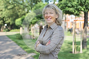 Outdoor portrait of positive mature middle-aged woman