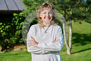 Outdoor portrait of positive teenage female looking at camera