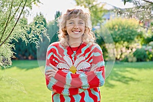 Outdoor portrait of positive teenage female looking at camera