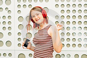 Outdoor portrait of pretty teenage girl with red dyed hair