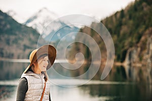 Outdoor portrait of pretty young kid girl visiting Alpsee lake in Bavaria