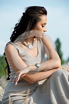 Outdoor portrait of romantic charming lady with closed eyes relaxing on the beach on a sunny summer day