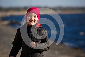 Outdoor portrait of running cheerful little girl