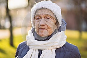 Outdoor portrait of senior woman in jacket , scarf and head wear in winter. Happy retirement. Joyful elderly person posing in the