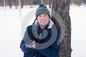 Outdoor portrait of smiling handsome man in coat and scurf