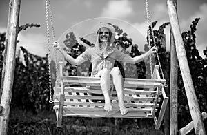 Outdoor portrait of a smiling happy girl. Sensual woman swinging on swing on summer nature, young sexy girl relaxing in
