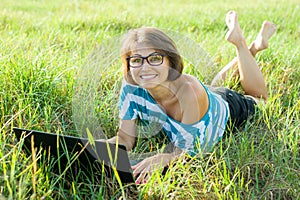 Outdoor portrait smiling middle-aged woman freelancer blogger traveler with laptop on nature