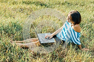 Outdoor portrait smiling middle-aged woman freelancer blogger traveler with laptop on nature