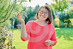 Outdoor portrait of smiling middle aged woman looking at camera