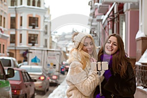 Outdoor portrait of smiling pretty women friends making selfie a