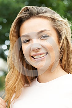 Outdoor Head And Shoulders Portrait Of Smiling Teenage Girl