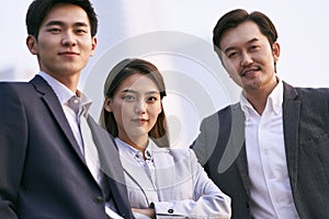 Outdoor portrait of three asian business people
