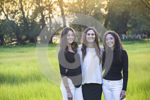 Outdoor Portrait of three beautiful Hispanic women standing together outdoors