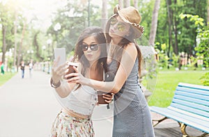 Outdoor portrait of three friends take selfie with smartphone