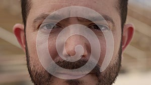 Outdoor portrait of an ugly man looking at the camera with serious face. Close-up of a serious male face