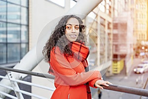 Outdoor portrait of woman in orange coat visiting a Europe city