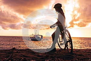 Outdoor portrait of young asian woman posing with bicycle