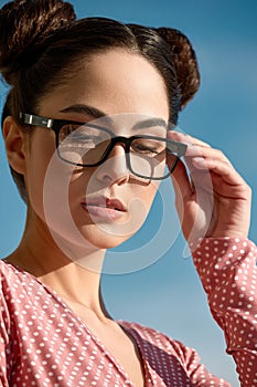Outdoor portrait of a young beautiful confident woman posing on the street. Model wearing stylish glasses. Female
