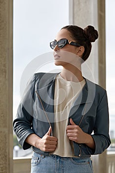 Outdoor portrait of a young beautiful confident woman posing on the street. Model wearing stylish sunglasses. Girl