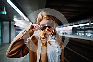 Outdoor portrait of a young beautiful confident woman posing The train station on the background