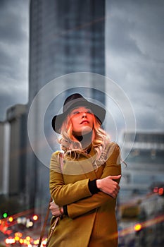 Outdoor portrait of a young beautiful fashionable lady wearing olive coat
