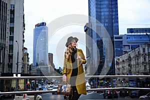 Outdoor portrait of a young beautiful fashionable lady wearing olive coat