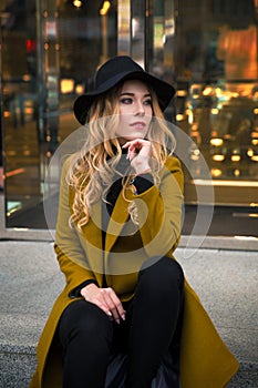 Outdoor portrait of a young beautiful fashionable lady wearing olive coat