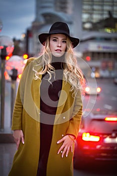 Outdoor portrait of a young beautiful fashionable lady wearing olive coat