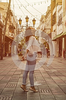 Outdoor portrait of young beautiful girl 9 to 25 years old posing in street. wearing white blouse and tight jeans