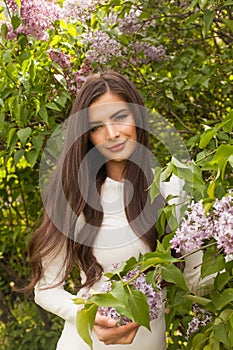 Outdoor portrait of young beautiful happy smiling lady posing with flowes