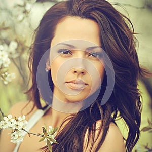 Outdoor portrait of young beautiful woman with chic curly brown