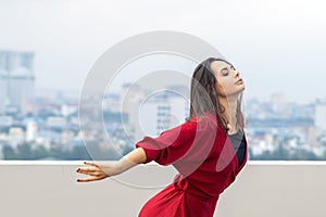 Outdoor portrait of young beautiful woman dancing on the rooftop