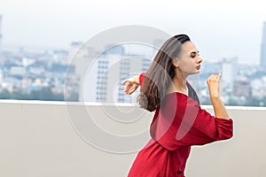 Outdoor portrait of young beautiful woman dancing on the rooftop