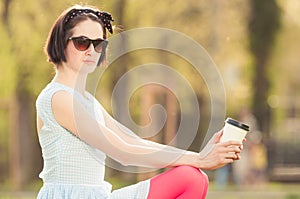 Outdoor portrait of young beautiful woman enjoyng coffee