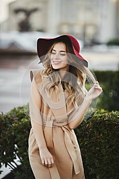 Outdoor portrait of a young beautiful woman with long platinum blond hair in modish outfit. Model girl in stylish coat