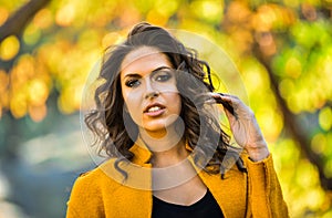 Outdoor portrait of a young brunette woman in autumn park.