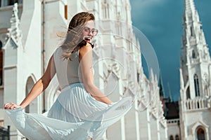 Outdoor portrait of young elegant woman walking in Budapest street. Young fashion model, urban style. Movement excited
