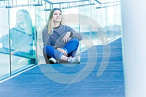 outdoor portrait of young happy smiling teen girl on a glass bridge on natural background