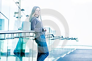 outdoor portrait of young happy smiling teen girl on a glass bridge on natural background
