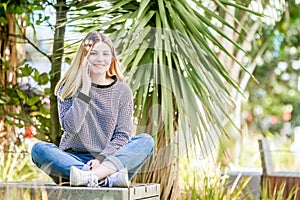 outdoor portrait of young happy smiling teen girl using cell phone, natural outdoor background