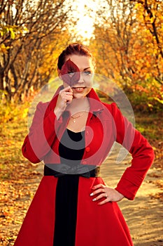 Outdoor portrait of young redheaded woman in autumn forest