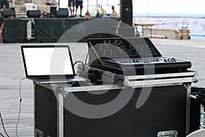 Outdoor professional audio mixer consolle and a computer with clipping path on the screen and a  stage on the foreground