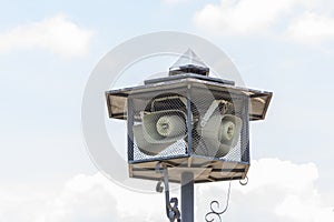 Outdoor public address loudspeakers against a blue