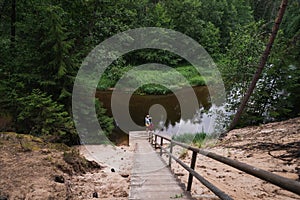 Outdoor recreation in Estonia. Mom and daughter near the forest river Valge on a summer day