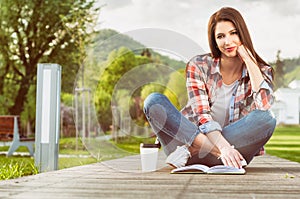 Outdoor relaxation concept with beautiful woman reading a book