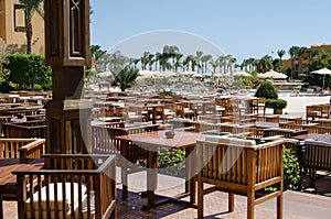 Outdoor restaurant of the hotel with wooden tables and chairs, Hurgada, Egipt