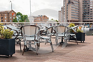 Outdoor restaurant tables and chairs in St Katherine\'s Dock in London, UK