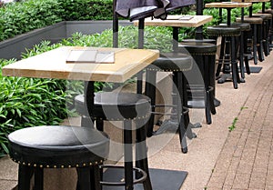 Outdoor restaurant tables and leather high stools