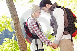 Outdoor romance. A happy young couple standing face to face and holding hands while out in nature.