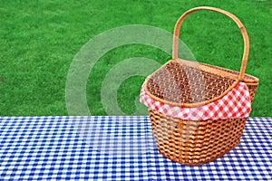 Outdoor Rustic Picnic Table With Hamper And Blue Tablecloth
